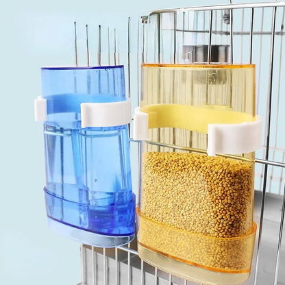 Snugll automatic bird feeder with transparent yellow and blue containers attached to a birdcage
