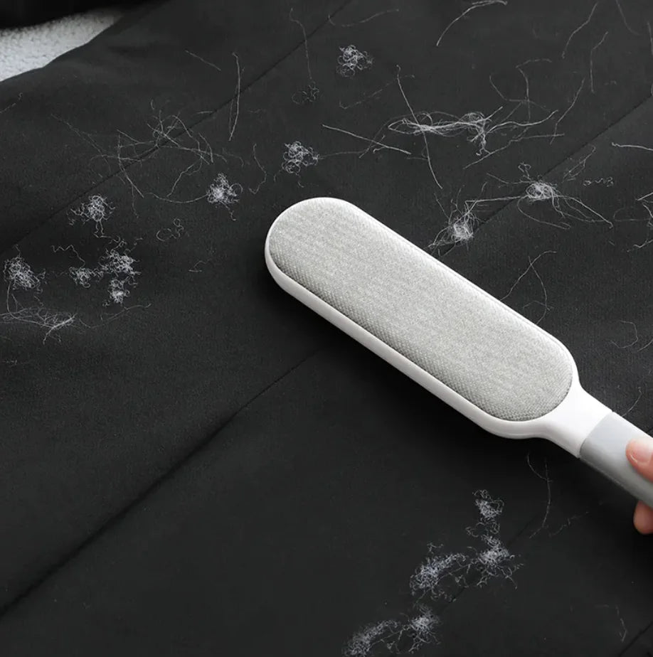 Snugll electrostatic pet hair remover cleaning white pet hair from black fabric surface