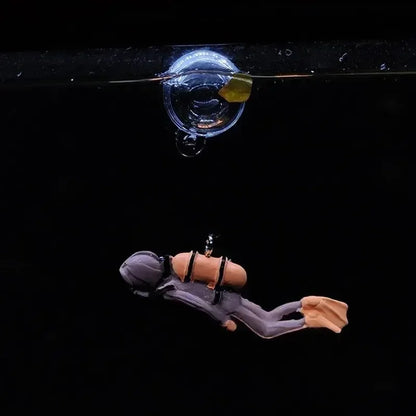 Snugll floating blue diver aquarium decor attached to tank wall with suction cup under water