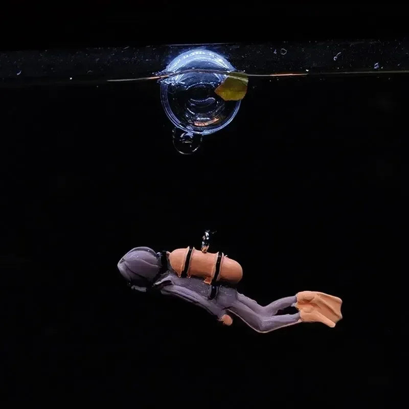 Snugll floating blue diver aquarium decor featuring a miniature diver attached to a suction cup in a black background