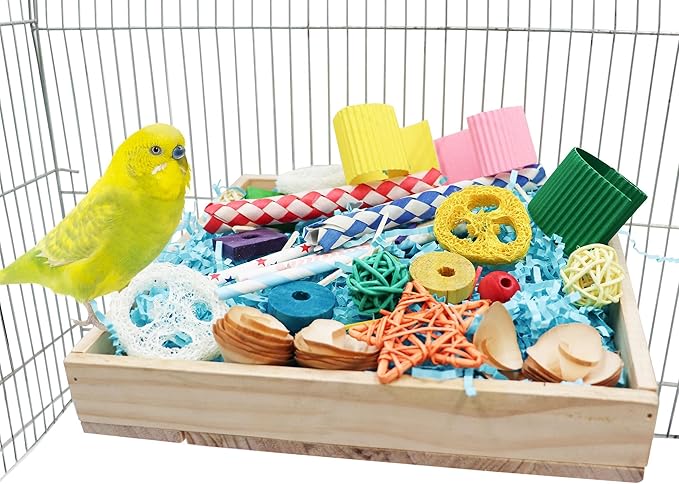 Parrot chew toys box filled with colorful natural wood and woven bird toys beside a yellow parakeet