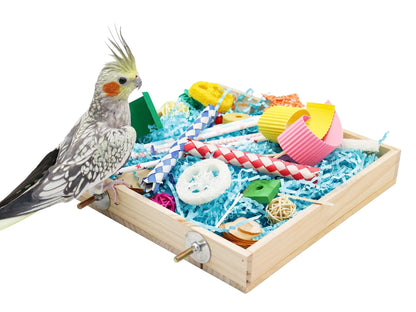 Parrot chew toys box with colorful wooden and rope toys beside a cockatiel bird